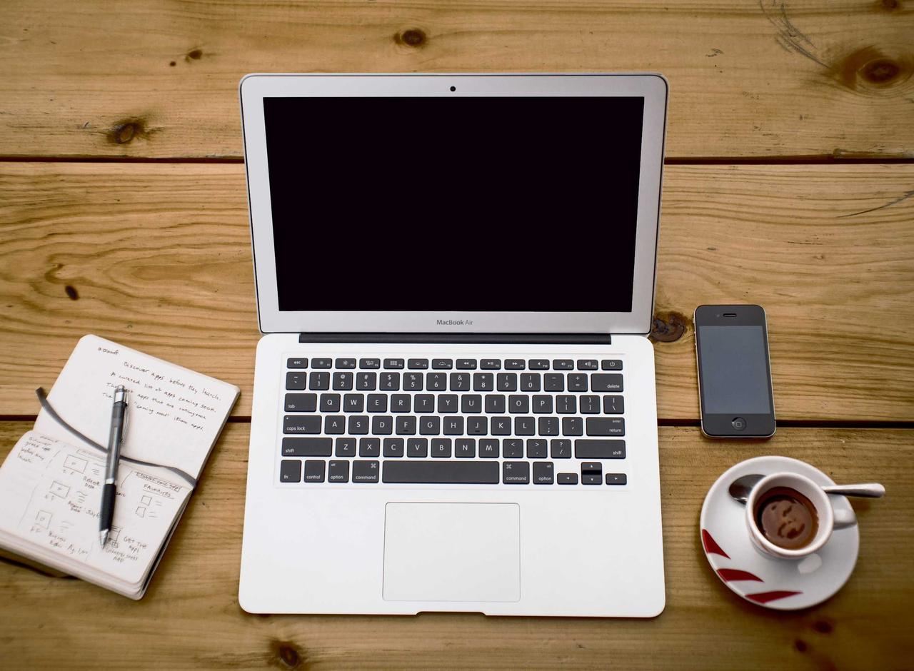A laptop and notebook on a clean desk, with a build pipeline open on screen.